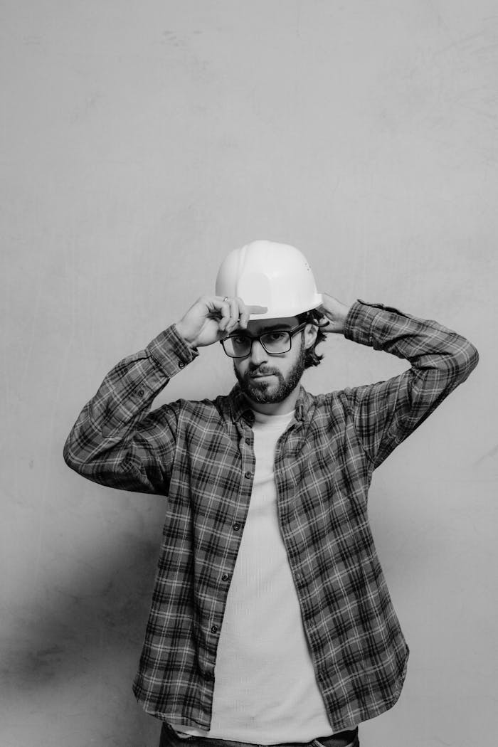 why-choose-us Black and white photo of a male construction worker wearing a hard hat and glasses.